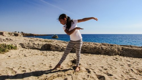 Niña haciendo danza en la playa.