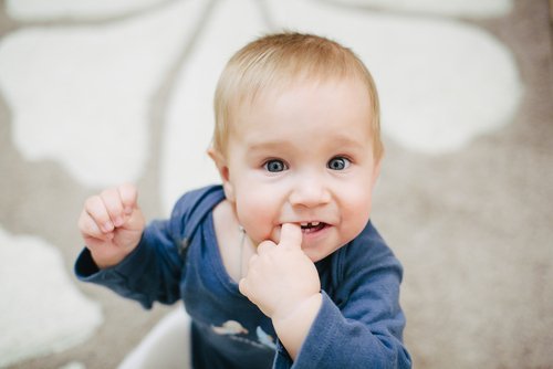 En bebis som tuggar på sitt pekfinger.