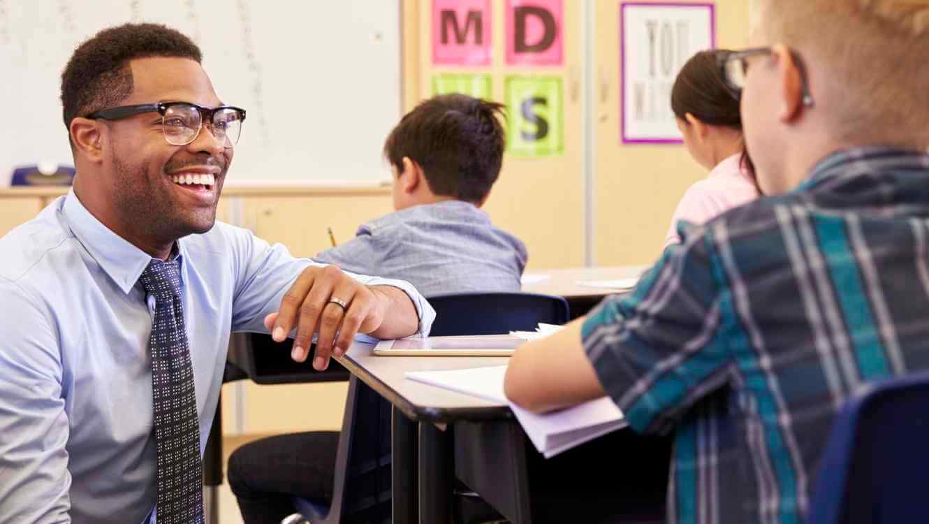 maestro con gafas sonriendo a niño