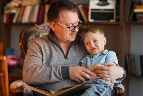 Abuelo leyendo un libro a su nieto.