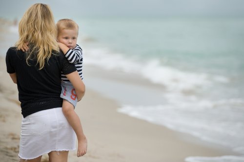 Madre con su hijo disfrutando de un día nublado de playa.