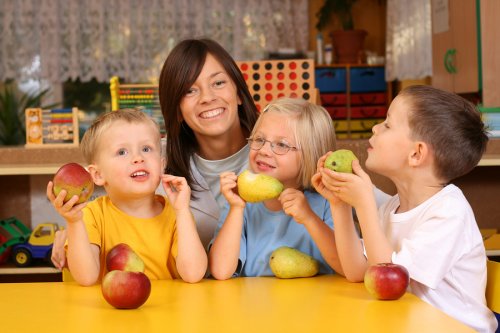 Niños comiendo fruta como parte de una alimentación saludable.