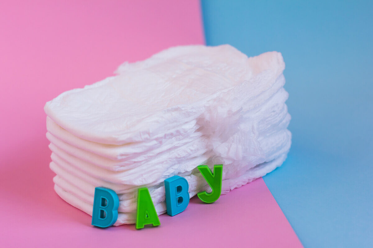 Pañales de bebé sobre superficie de color rosa y azul.