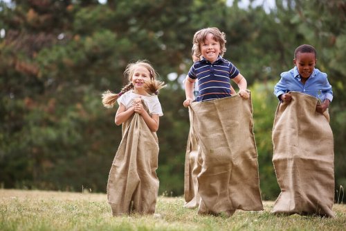 Niños jugando a las carreras de sacos.