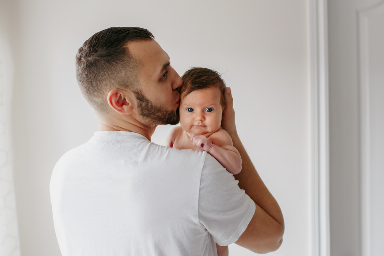 Un père qui tient son bébé dans ses bras.