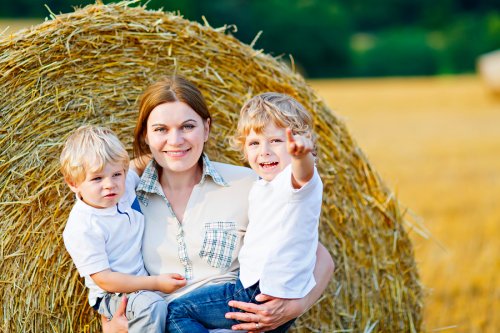 Madre cogiendo en brazos a sus hijos para no hacerlos sentir que son un sacrificio.