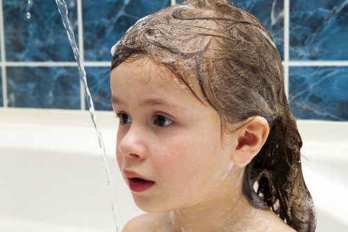 lille pige i bad med sæbe i håret