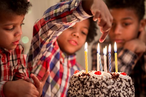 Garçon ayant sept ans. Elle a un gâteau devant elle avec des bougies.