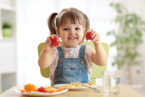 Une jeune fille qui mange une salade de tomates.