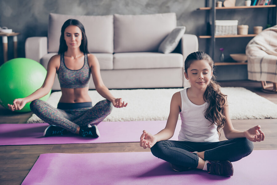 En mor og datter som praktiserer meditasjon.