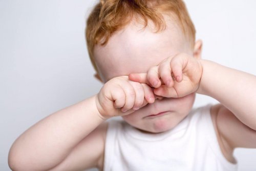 Un bébé qui se frotte les yeux.