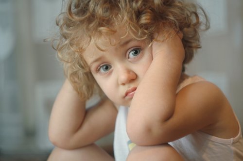 Niño triste porque tiene que dejar de jugar y sus padres no son capaces de validar sus emociones.