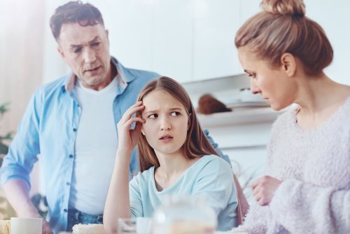 Padres regañando a su hija por su comportamiento. Se han puesto de acuerdo en la educación de sus hijos.