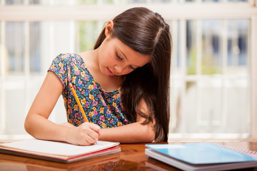 En ung jente som skriver i en notatbok.