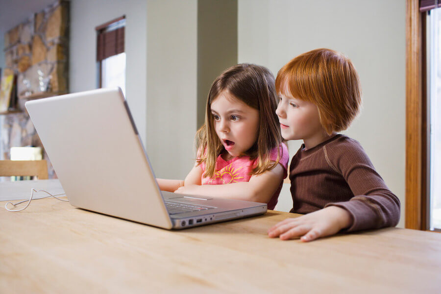 Niños emprendedores navegando por Internet con un ordenador.