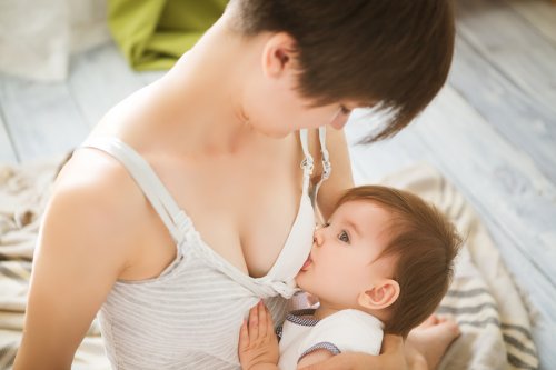 Mamá dando el pecho a su bebé usando uno de los vestidos para la lactancia materna.
