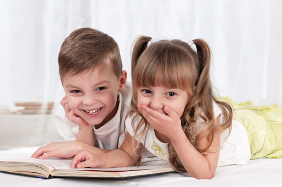 Deux enfants qui regardent un livre.