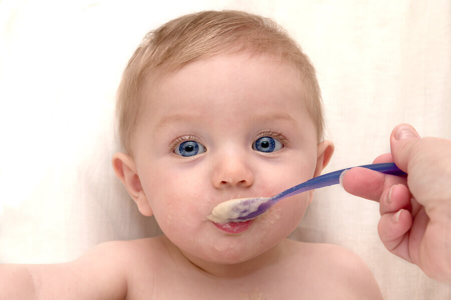 A baby eating baby food.