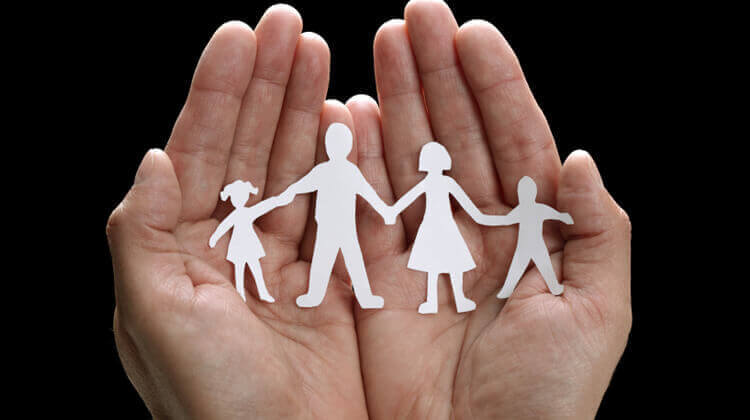 Familia de papel en las manos.