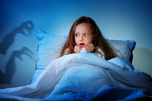Niña teniendo una pesadilla durante la noche.