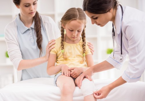 Niña en el médico con una venda en la rodilla con signos de artrosis infantil.