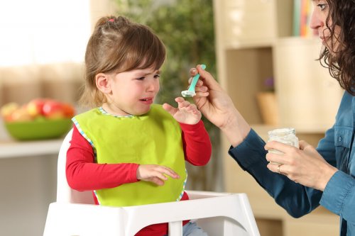 Niña rechazando la comida debido al trastorno de alimentación selectiva en la infancia.