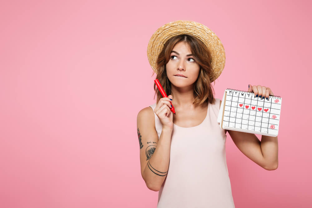 Une femme qui examine son calendrier menstruel.