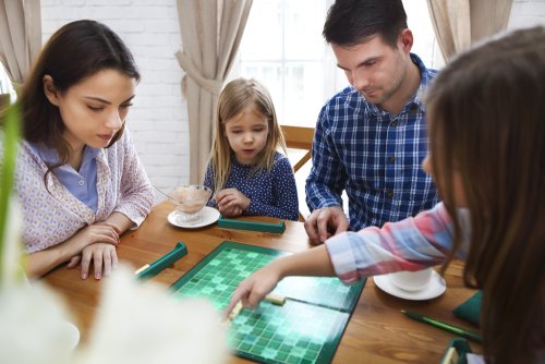 Familia jugando al scrabble para mejorar la ortografía.