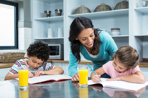 Madre ayudando a su hijos a escribir la carta a los Reyes Magos.