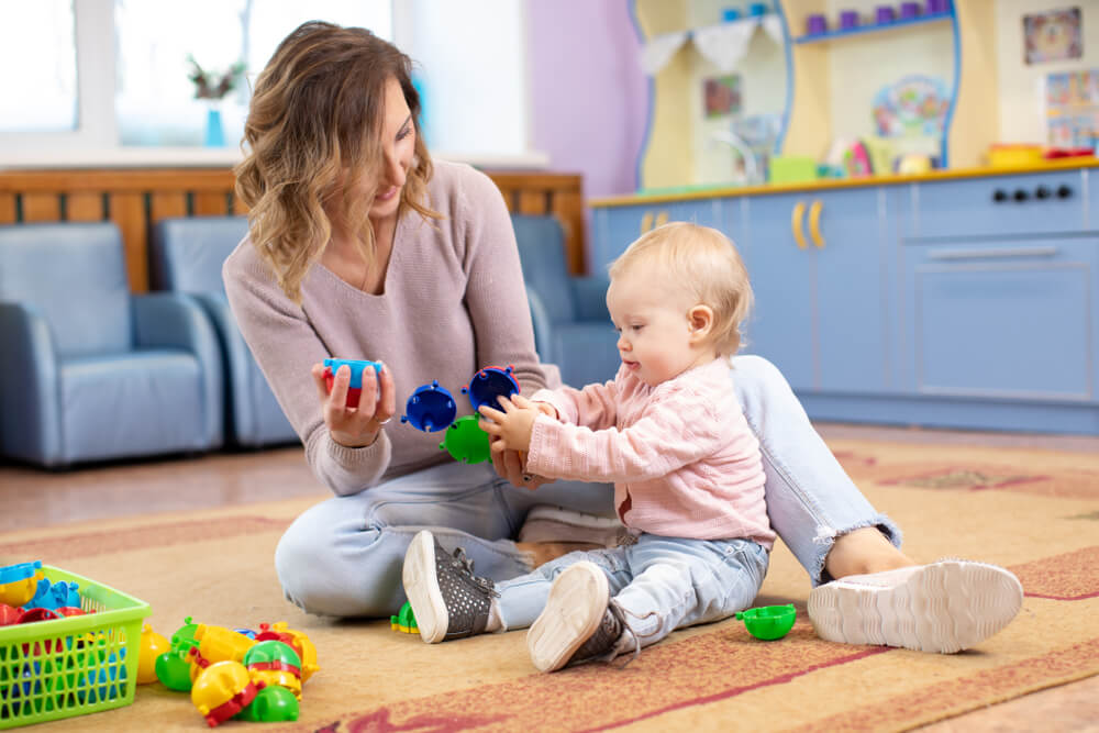 Une maman qui joue avec son enfant à la maison.