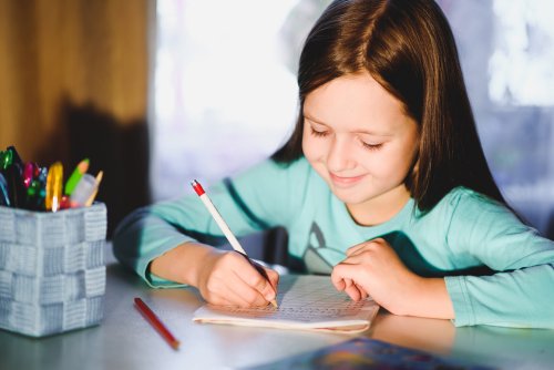 Niña escribiendo para mejorar su caligrafía.