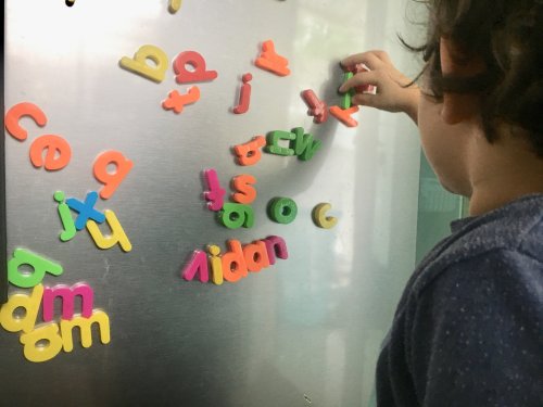 Niño escribiendo en la nevera para mejorar su ortografía.