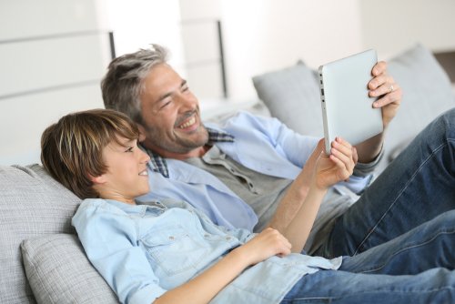 Padre e hijo trabajando en un proyecto en Internet juntos.