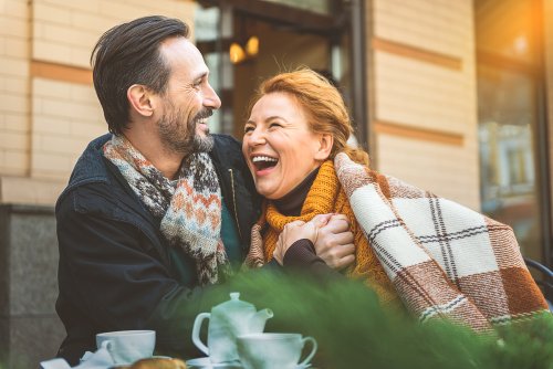 Una pareja muy feliz recupera la ilusión tomando café en la terraza de una cafetería.