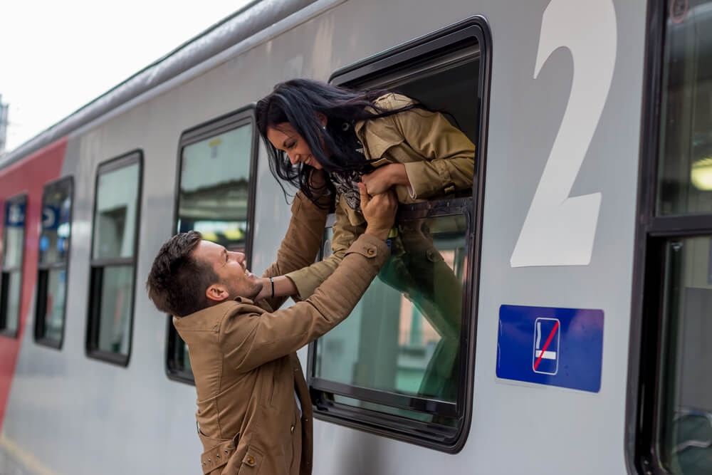 Una pareja se despide en el tren porque uno de ellos trabaja fuera de casa.