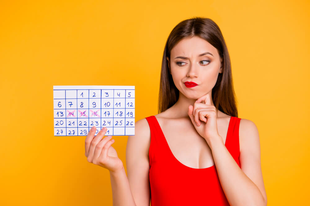 A woman looking at a calendar.