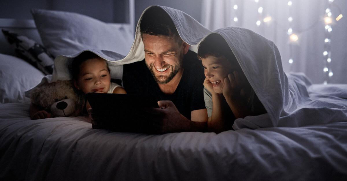 Niños viendo una película con su padre como parte del ocio