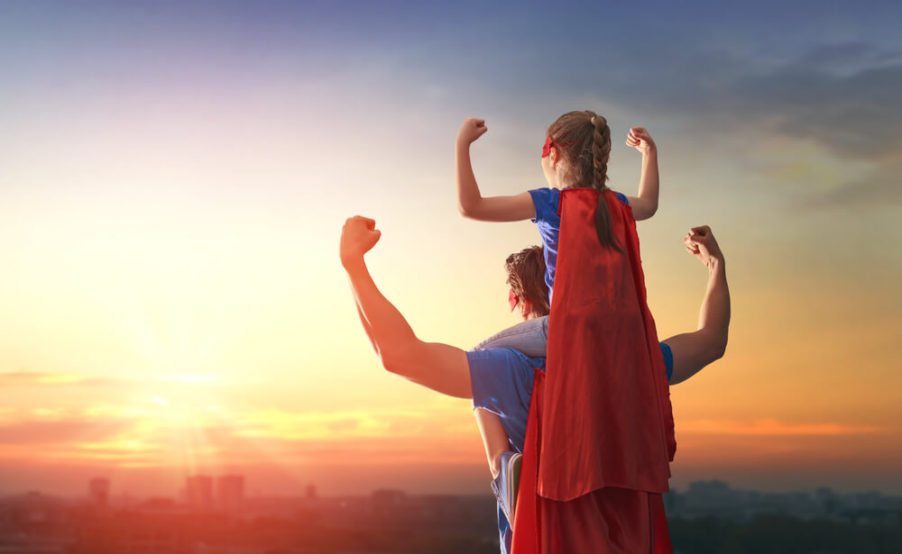 A father and daughter dressed as superheroes.