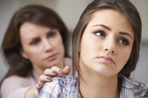 Madre intentando hablar con su hija para sobrellevar juntas la adolescencia.
