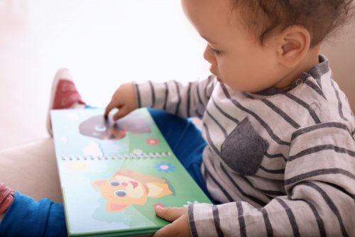 Niño leyendo un cuento para bebé de 0 a 3 años.