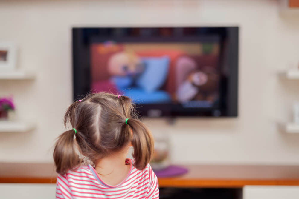 Une jeune fille qui regarde la télévision.