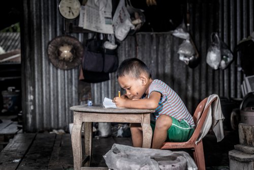 Niño desfavorecido recibiendo una educación en su casa gracias a las acciones de UNICEF para proteger a los niños.