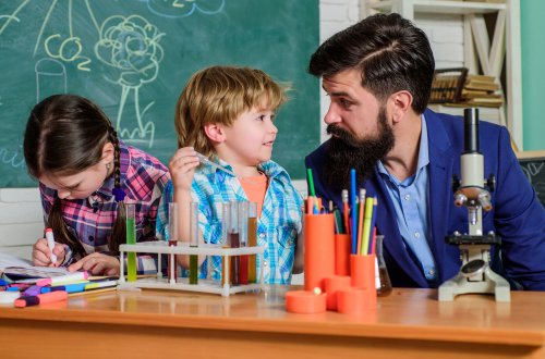 Profesor con sus alumnos en el laboratorio de ciencias haciendo una práctica para poner en relación con la pedagogía de la realidad.