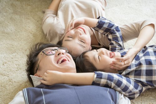 Hijo abrazo a su padre y madre tumbados en el suelo.