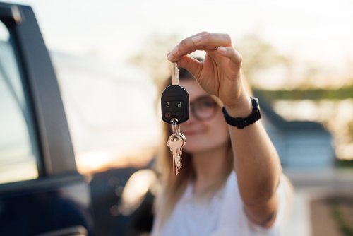 Hija con las llaves del coche para aprender a conducir.