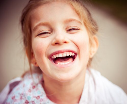 Niña sonriendo de felicidad.