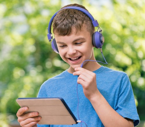 Niño hablando por la tablet al aire libre.