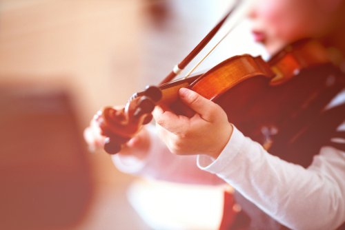 Niño tocando el violín en clase de enseñanzas artísticas.