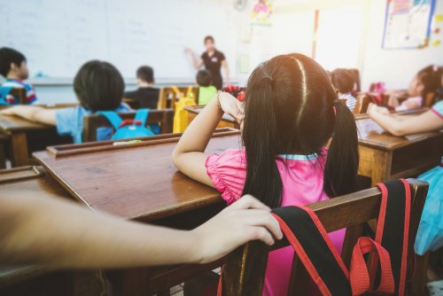 Niños en clase con un gran deseo de aprender gracias a la profesora.