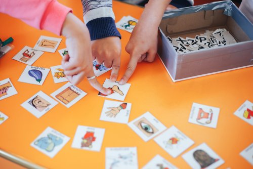 Niños jugando con tarjetas para aprender otro idioma.